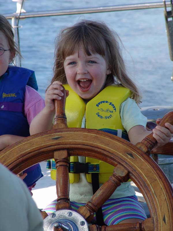 young girl at the helm of viva with big grin